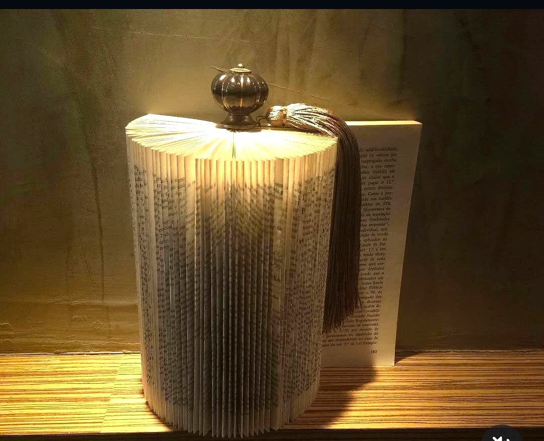 Luminária de livro dobrado com pingente decorativo, criada por aluna