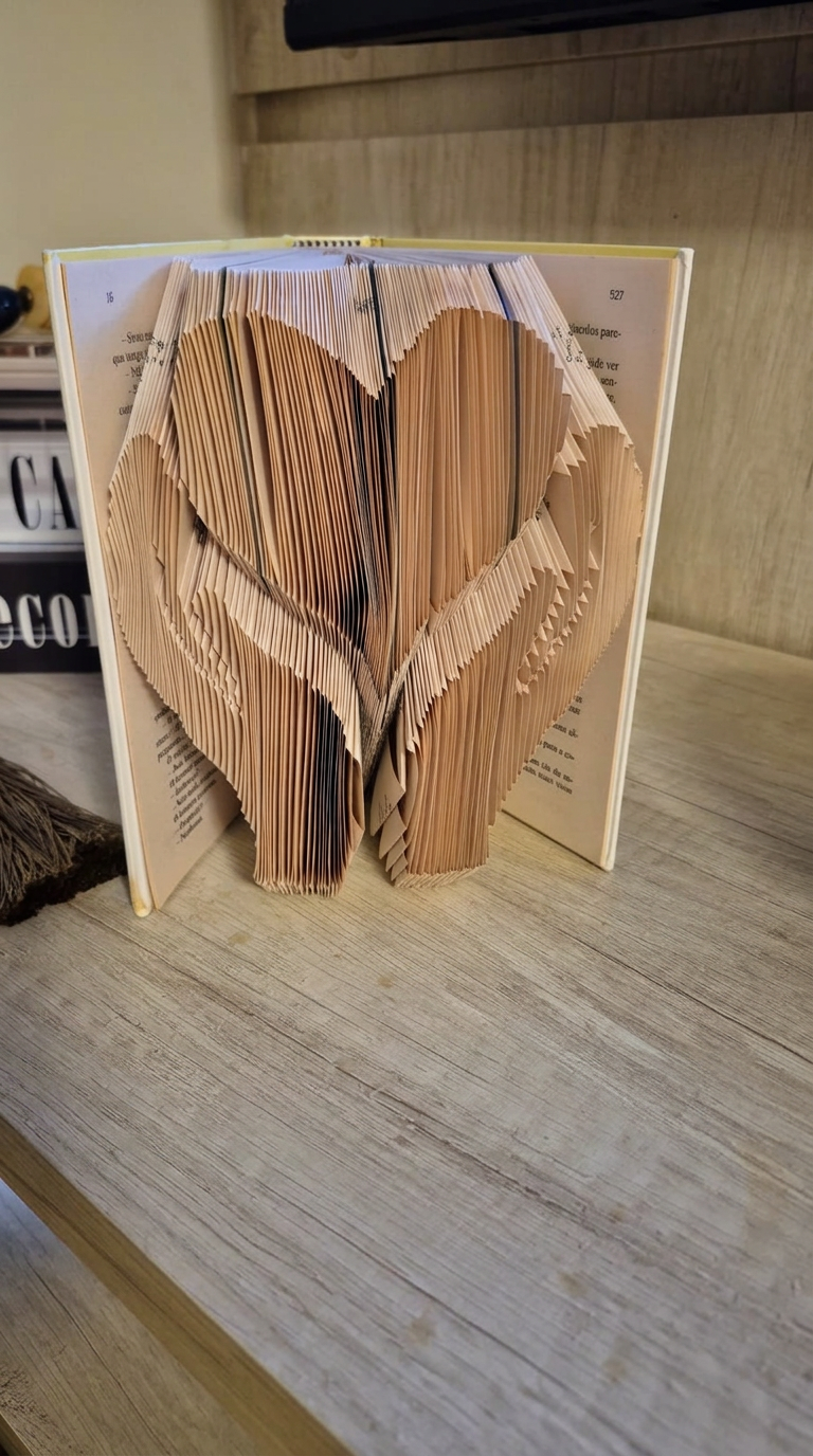 Escultura de livro em camadas formando um coração, feita por aluna